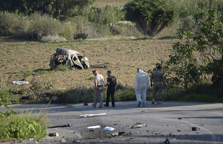 Police and forensic experts inspect the wreckage of a car bomb that killed journalist and blogger Daphne Caruana Galizia close to her home in Bidnija, Malta. (STR/AFP)