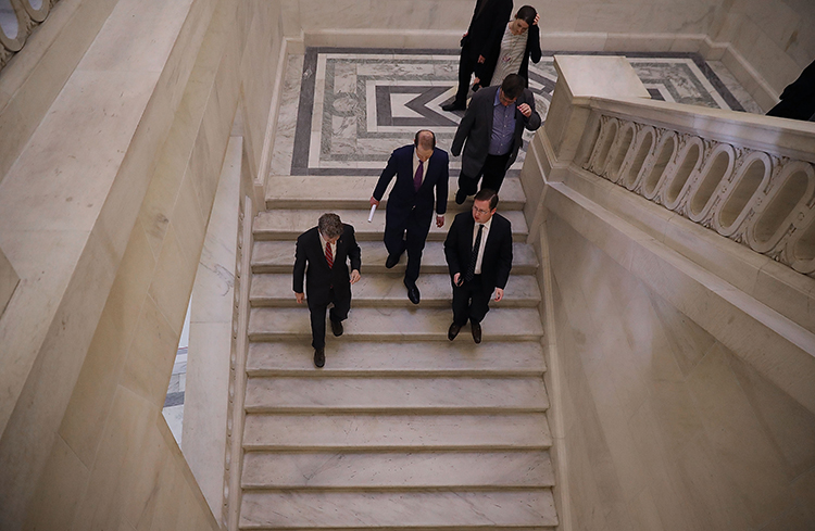Senators talk together in the the Russell Senate Office Building after leaving a January 16 news conference about proposed reforms to FISA. The Senate has reauthorized Section 702 of the act in a move that could put journalists at risk. (Chip Somodevilla/Getty Images/AFP)