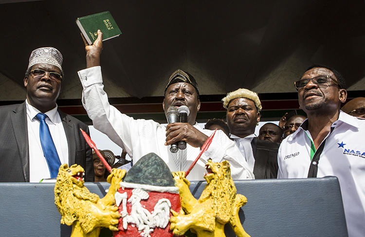 Kenya's opposition coalition leader Raila Odinga holds a bible as he declares himself the 'people's president' in Nairobi on January 30. Authorities cut the transmissions to four broadcasters over their attempted live coverage of the event. (AFP/Patrick Meinhardt)