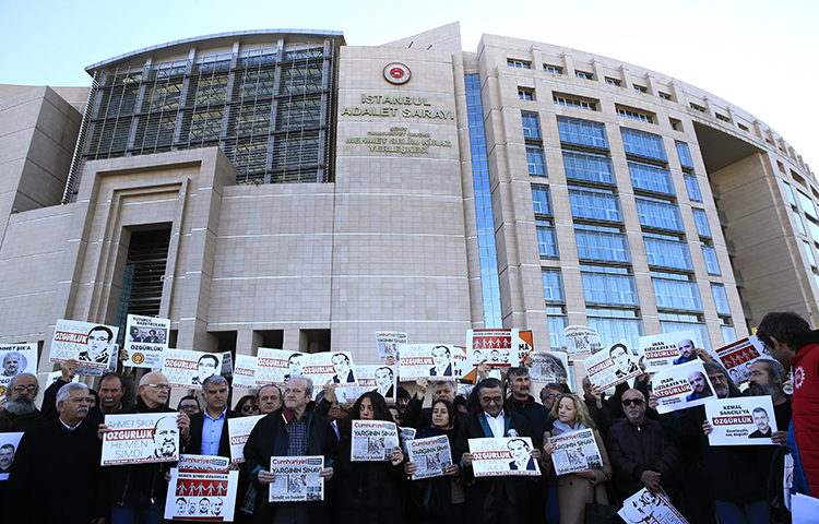 Demonstrators hold placards and copies of the Cumhuriyet daily newspaper as they stage a protest outside a court where the trial of about a dozen employees of the newspaper on charges of aiding terror groups, continues in Istanbul, Tuesday, Oct. 31, 2017. The trial against opposition daily Cumhuriyet continued on December 25, the newspaper reported. (AP/Lefteris Pitarakis)