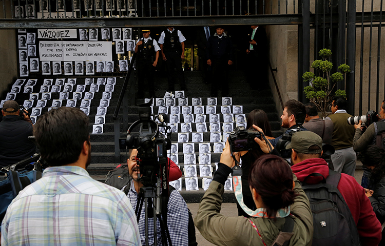 A photographer takes pictures of images of reporter Candido Rios, who was killed in Veracruz, during a demonstration against his killing, at the Interior Ministry building in Mexico City, Mexico on August 24, 2017. Last year, at least six reporters were murdered in Mexico in retaliation for their work, according to CPJ research.(Reuters/Henry Romero)