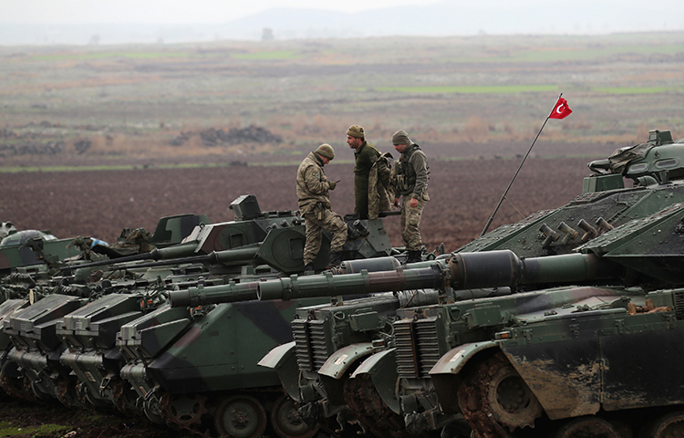 Turkish army tanks and armored personnel carriers are seen near the Turkish-Syrian border in Hatay province, Turkey on January 23, 2018. (Reuters/Umit Bektas)
