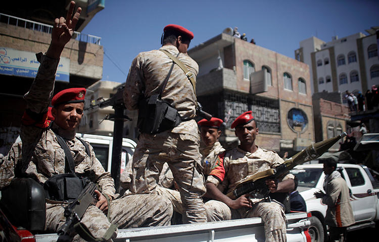 Military police ride on the back or a patrol truck as they secure a road where people held a ceremony commemorating the anniversary of the 2011 uprising that toppled Yemen's former president Ali Abdullah Saleh in Taiz, Yemen in February 2018. Yemeni authorities detained Awad Kashmeem, the former governor of the board of directors for the government-aligned newspaper November 30, in Mokalla, Hadramout Province, according to news reports. (Reuters/Anees Mahyoub)