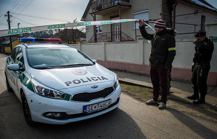 Policemen stand guard at the crime scene where Slovak investigative journalist Jan Kuciak and his girlfriend were murdered in Velka Maca, Slovakia, on February 26, 2018. (AFP/Vladimir Simicek)