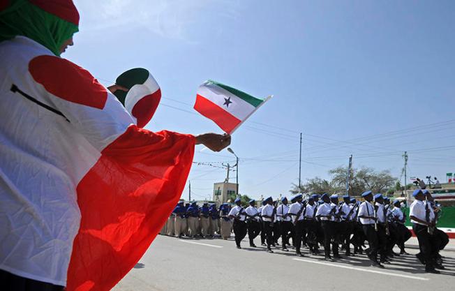 People wave flags as soldiers and other military personnel of Somalia's breakaway territory of Somaliland march past during an Independence day celebration parade in the capital, Hargeisa on May 18, 2016. Somaliland authorities detained journalist Mohamed Aabi Digaale on February 17, 2018. (Mohamed Abdiwahab/AFP)