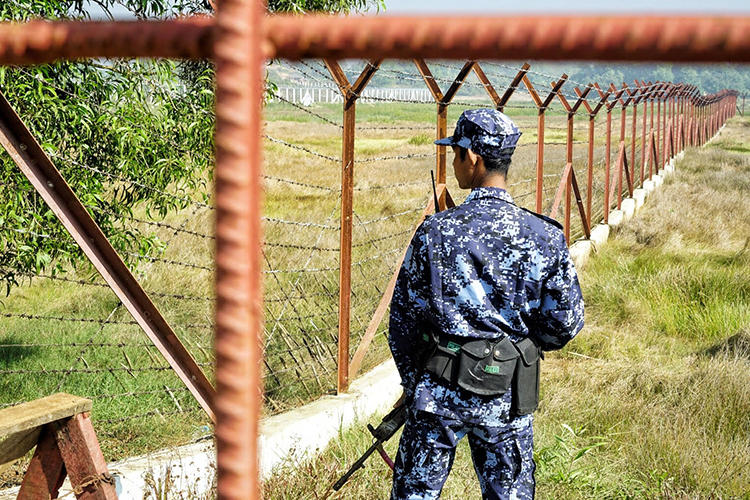 A Myanmar border guard stands next to fencing near Maungdaw, Rakhine state, where structures to process Rohingya refugees are being built. Local and international journalists face challenges reporting on the crisis and other politically sensitive issues. (AFP/Cape Diamond)