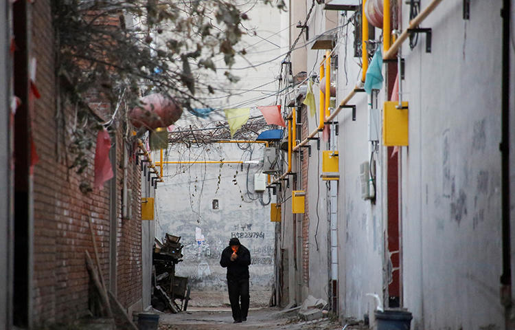 A man walks through an alley between residential houses in Hebei province, China in December 2017. Picture taken December 7, 2017. A group of men assaulted and robbed two television journalists while they were reporting on allegations of industrial pollution in the province in late January 2018. (Reuters/Thomas Peter)