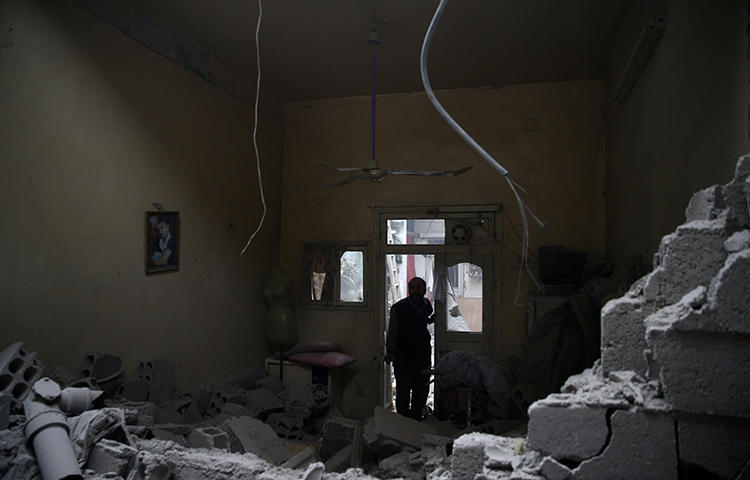 A man inspects a damaged house in the besieged town of Douma in eastern Ghouta in Damascus, Syria, on February 22, 2018. Eastern Ghouta has been under constant shelling, airstrikes, and rocket fire from al-Assad forces and their allies since February 18, 2018 to the date of publication, according to news reports. (Reuters/Bassam Khabieh)