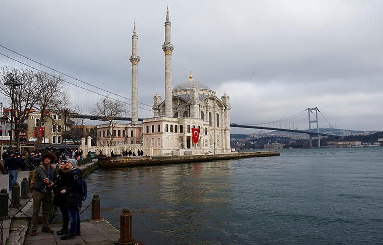 People take souvenir photos along the Bosphorus in Istanbul, Turkey in February 2018. Turkey continues to crackdown on the press; a Turkish court sentenced four journalists to life without parole on February 16, 2018, on charges relating to their journalistic activity. (Reuters/Osman Orsal)