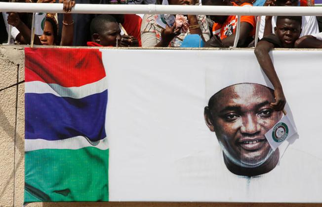 A supporter of Gambia's President Adama Barrow waves an ECOWAS flag at his swearing-in ceremony in February 2017. An ECOWAS court ruling calls on Gambia to repeal its criminal libel and false news laws. (Reuters/Thierry Gouegnon)