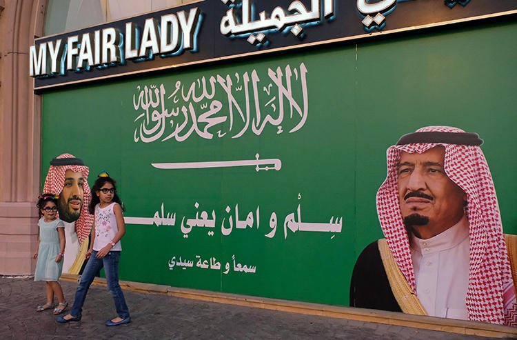 A poster in Jeddah depicts Saudi Arabia's King and Crown Prince. A Saudi court has jailed a journalist for five years for insulting the royal court. (Reuters/Reem Baeshen)