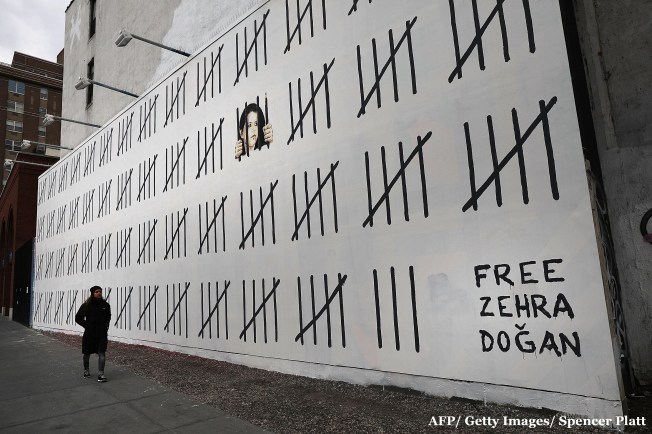 Pedestrians walk by the latest work by the elusive British street artist Bansky along a wall in New York City on March 16, 2018. The work draws attention to the jailed Turkish artist Zehra Doguan.(AFP/ Getty Images/ Spencer Platt)