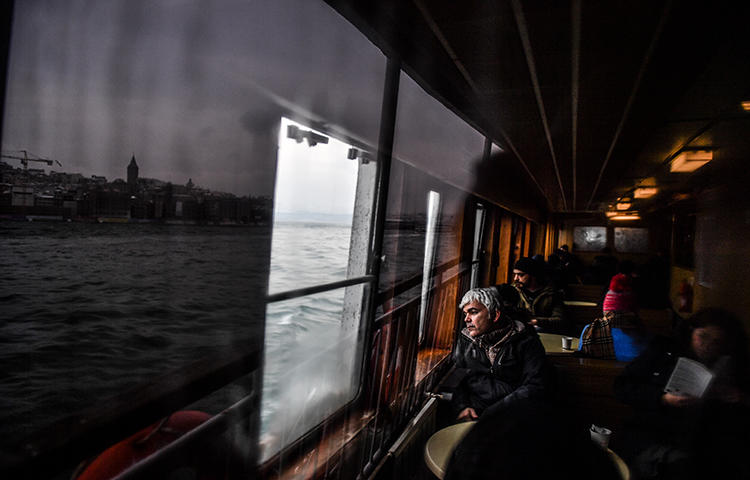 People look at the Bosphorus as they travel in a ferry from the Asian to the European side of Istanbul on March 1, 2018. The Turkish government continues its crackdown on the media. (AFP/ Bulent Kilic)