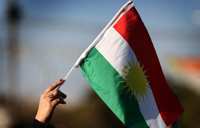A Syrian Kurd waves the Kurdish flag in Erbil in Kurdish-controlled northern Iraq. Kurdish security forces have attacked and detained journalists covering protests against austerity measures taken by the Kurdistan Regional Government, according to news reports. (AFP/Safin Hamed)