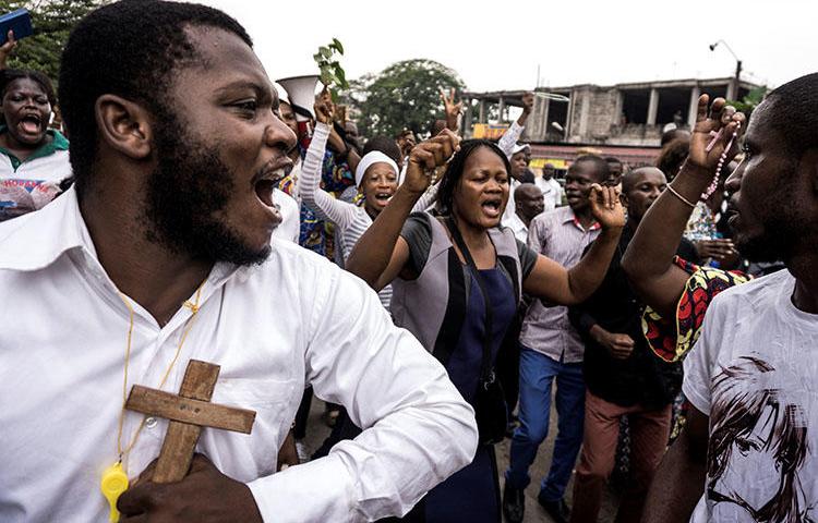 Catholics sing and dance during a December 31, 2017 demonstration to call for the President of the Democratic Republic of the Congo to step down. At least three journalists covering the rallies in Kinshasa say police harassed them. (AFP/John Wessels)
