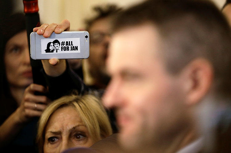 A journalist holds a phone with a sticker commemorating the assassinated Slovakian journalist Jan Kuciak, as Slovak deputy Prime Minister Peter Pellegrini talks to the media after a meeting at the presidential palace in Bratislava on March 15, 2018. (REUTERS/David W. Cerny)