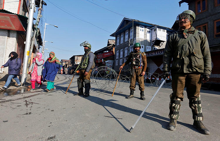 Indian policemen stand guard on a road, after Kashmiri separatists called for a day-long strike against the recent killings in Kashmir in March 2018. Kamran Yousuf, a freelancer working in the Jammu and Kashmir region, who contributes to the daily Greater Kashmir, has been in custody since September 5, 2017. (Reuters/Danish Ismail)