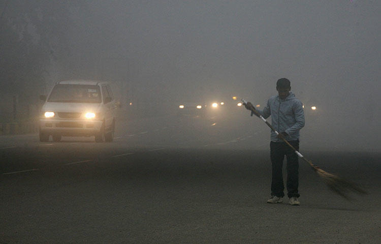 A sweeper cleans a busy road in India's capital New Delhi in January 2011. Two journalists in Bihar state died after a car ran them over on March 25, according to reports. (Reuters/Parivartan Sharma)