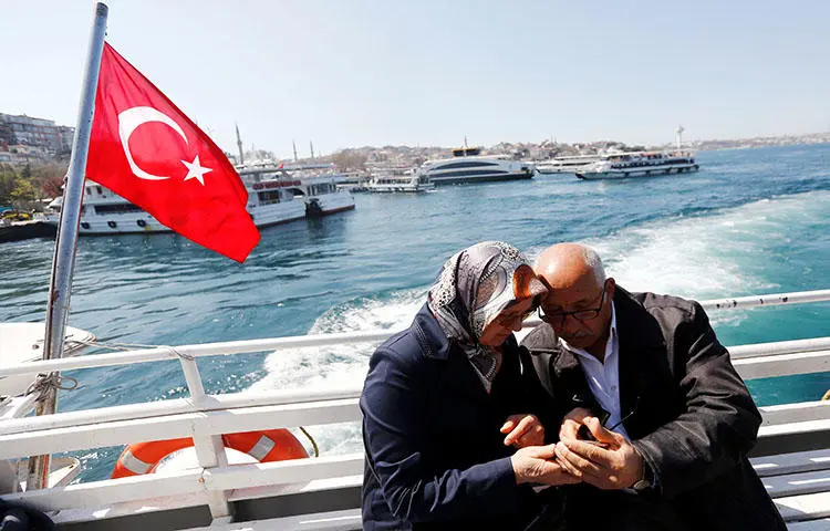 A couple check their mobile phone as they travel in a ferry in Istanbul, Turkey in April 2017. An Istanbul court on March 8, 2018, sentenced at least 22 journalists to prison on terrorism-related charges, according to news reports. (Reuters/Murad Sezer)