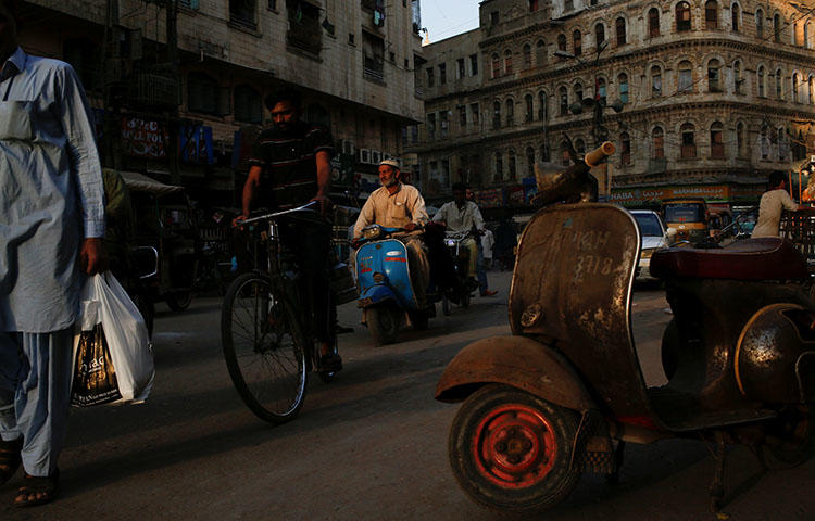 A man rides a scooter on a busy street in Karachi, Pakistan in March 2018. The privately owned Pakistani television channel Geo TV is not accessible throughout parts of the country including Karachi, according to reports.(Reuters/Akhtar Soomro)