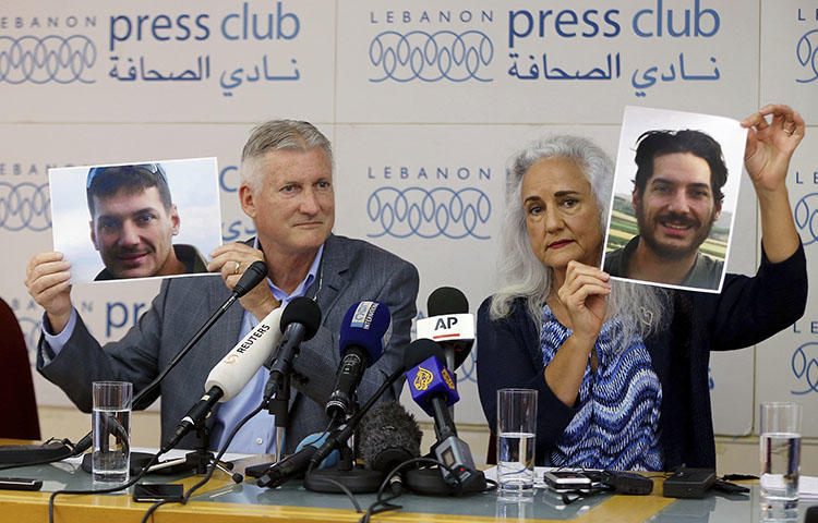 Austin Tice's parents, Marc and Debra, hold up photos of him during a press conference in Lebanon in July 2017. (AP/Bilal Hussein)