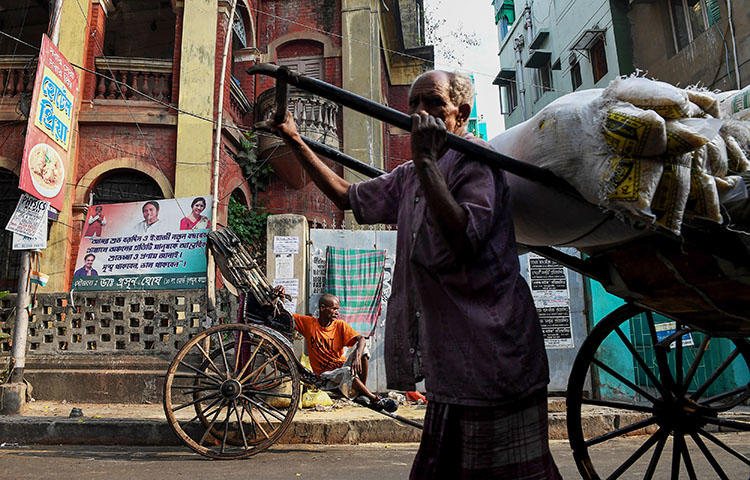 An Indian rickshaw puller waits for commuters as another rickshaw transports goods in Kolkata, India on March 12, 2018. Biplab Mondal, a photojournalist with the Times of India Kolkata city bureau, and Manas Chattopadhyay, a reporter with the regional ETV Bharat television channel, were attacked while covering elections in West Bengal, India. (AFP/Dibyangshu Sarkar)