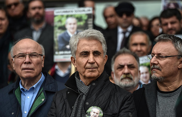 Cumhuriyet cartoonist Musa Kart, center, and colleagues stand outside an Istanbul courthouse in March 2018. A court in April convicted Kart and several of his colleagues of aiding a terrorist organization. (AFP/Ozan Lose)