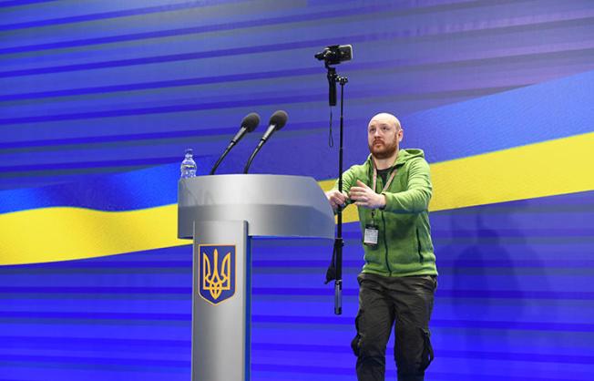 A journalist films before a presidential press conference in Kiev on February 28, 2018. A Kiev prosecutor is refusing to return the passport of Turan TV's correspondent Fikret Huseynli. (AFP/Sergei Supinsky)