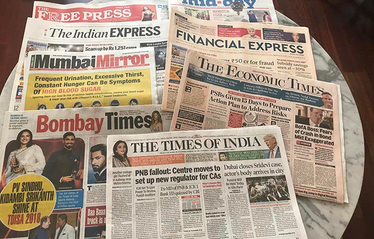 Copies of Indian newspapers are spread across a desk during a CPJ visit to the country in early 2018. (CPJ/Aliya Iftikhar)