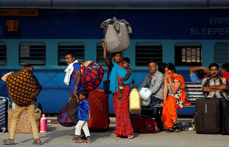 Passengers walk along a platform carrying luggage at a railway station in New Delhi, India in April 2018. Two unidentified persons on April 17 threw a gasoline bomb at the house of Patricia Mukhim, editor of the local Shillong Times newspaper, according to reports. (Reuters/Saumya Khandelwal)