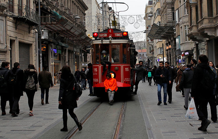 Boys stand on the edges of a vintage tram as it runs along the main shopping and pedestrian street of Istiklal in central Istanbul, Turkey in January 2018. Turkey continues to crackdown on media. (Reuters/Murad Sezer)