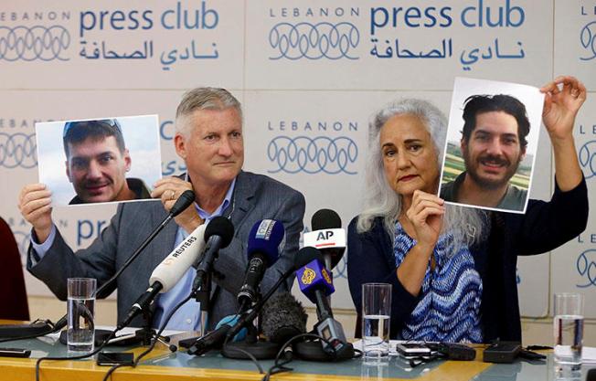 Marc and Debra Tice, the parents of Austin Tice, who went missing in Syria in 2012, hold up photos of him during a press conference at the Press Club in Beirut, Lebanon, on July 20, 2017. (AP/Bilal Hussein)