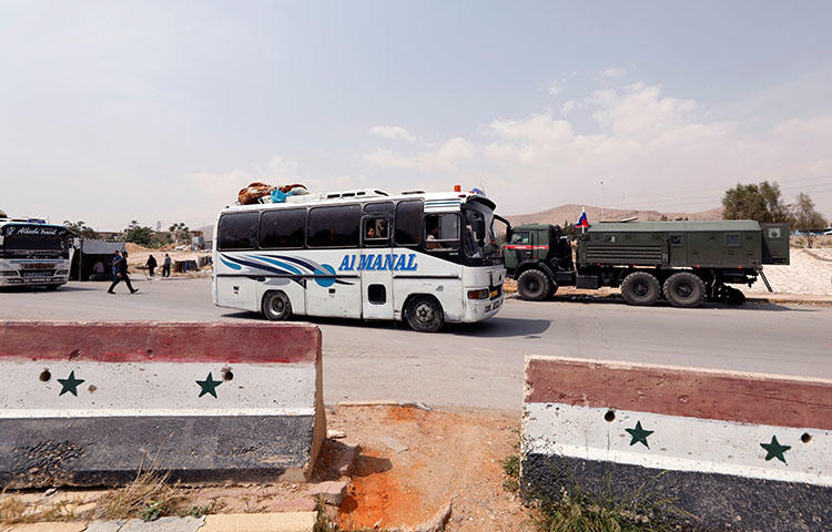 A bus carries rebels and their families who left Douma, at the entrance of the Wafideen camp in Damascus, Syria April 12, 2018. (Reuters/Omar Sanadiki)
