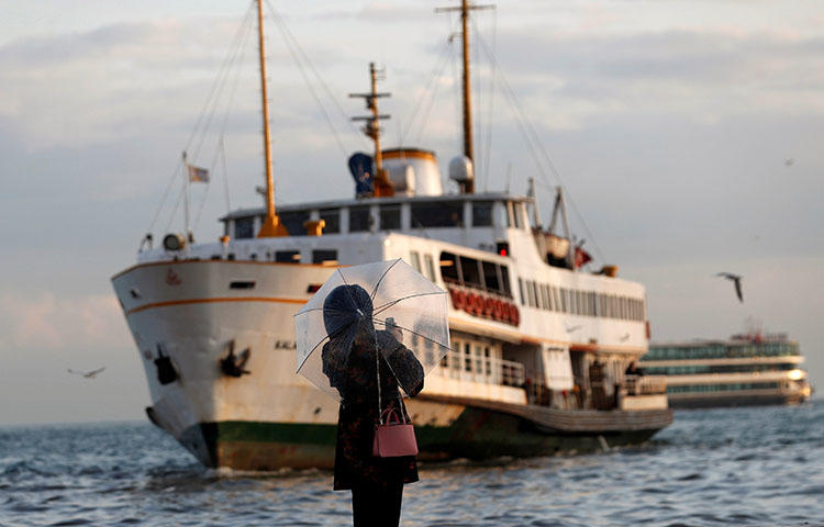 A woman takes pictures with her cellphone as a ferry approaches Besiktas pier in Istanbul, Turkey on March 27, 2018. Turkish authorities continue to crackdown on the country's press. (Reuters/Murad Sezer)