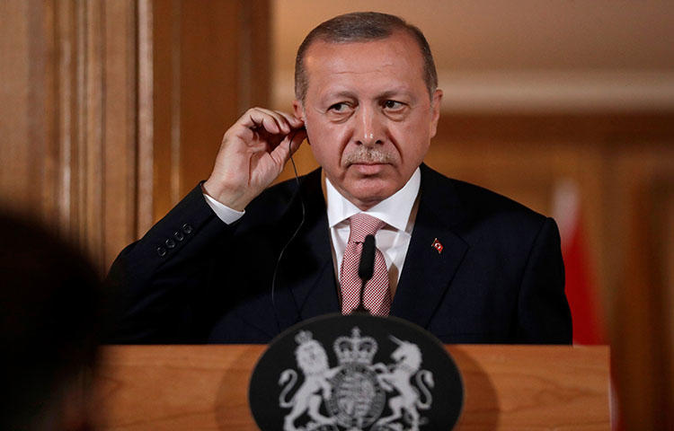 Turkey's President Recep Tayyip Erdogan listens via an interpreter as Britain's Prime Minister Theresa May speaks during a joint press conference in London on May 15, 2018. During the press conference Erdogan said that Turkey's jailed journalists are not, in fact, journalists, according to reports. (AFP/Matt Dunham)