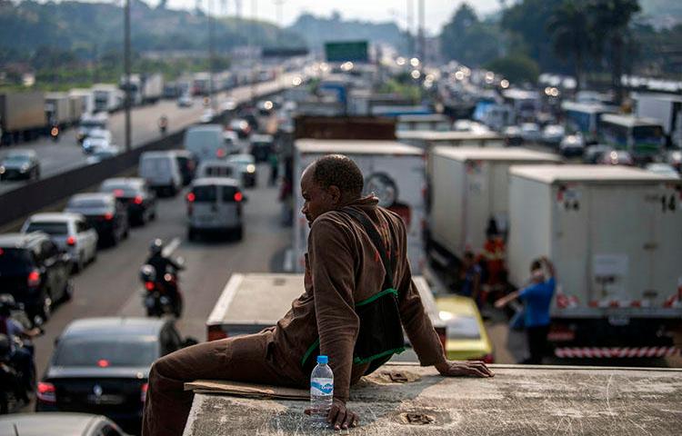 Brazilian truck drivers partially block a road during a nationwide strike to protest rising fuel costs in Rio de Janeiro, Brazil, on May 25, 2018. A radio host in northeastern Brazil has been subject to a series of threats in the first four months of 2018. (Mauro Pimentel/AFP)