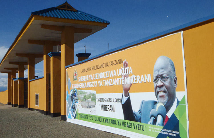 A banner of Tanzanian President John Magufuli adorns a wall around the country's tanzanite mines. Magufuli's government has imposed a series of restrictions on rights, including freedom of expression. (AFP/Joseph Lyimo)