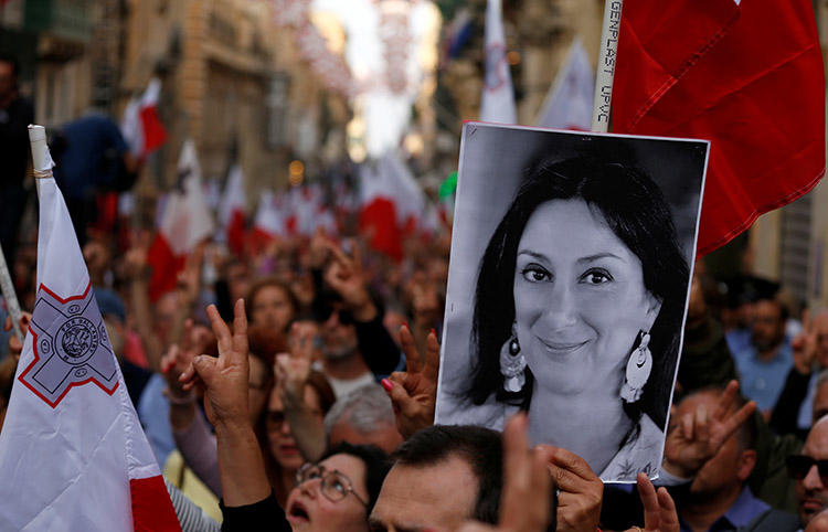 A poster of murdered journalist Daphne Caruana Galizia is carried at a protest against government corruption revealed by the Daphne Project, in Valletta, Malta, on April 29. Reporting on corruption can be a dangerous assignment. (Reuters/Darrin Zammit Lupi)