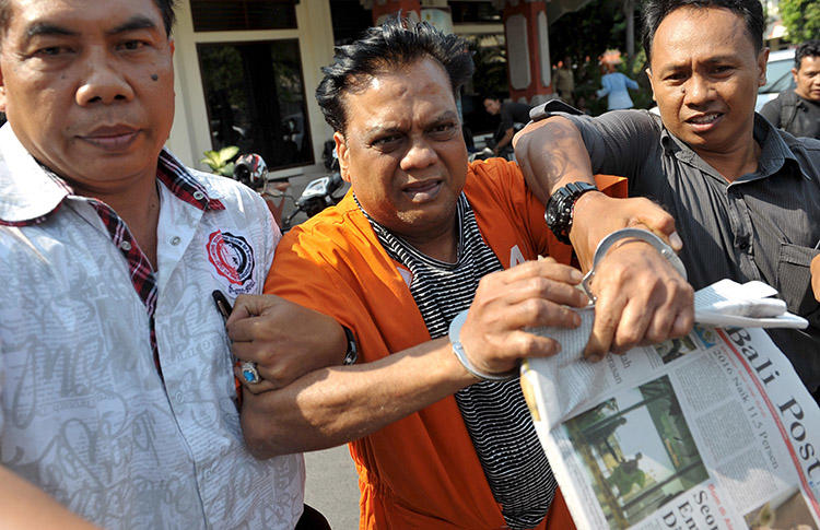 Indian crime boss Rajendra Sadashiv Nikhalje, center, is escorted by Indonesian police in 2015 after his arrest in Bali. A Mumbai court today sentenced him to life in prison for the murder of journalist Jyotirmoy Dey. (Reuters/Nyoman Budhiana/Antara Foto)