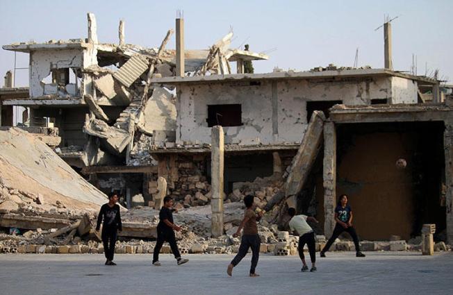 Children play football in front of a damaged building in a rebel-held neighborhood of Daraa in southern Syria on May 7, 2018. Unknown gunmen killed journalist Ibrahim al-Munjar in Daraa on May 17. (Mohamad Abazeed/AFP)