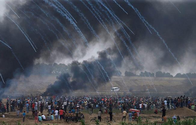 Tear gas canisters are fired by Israeli forces at Palestinian demonstrators on May 4, 2018. At least five Palestinian journalists were injured covering protests in the Gaza Strip on May 4 as the Israel Defense Forces used tear gas and fired live rounds to disperse demonstrators, according to reports. (Reuters/Mohammed Salem)