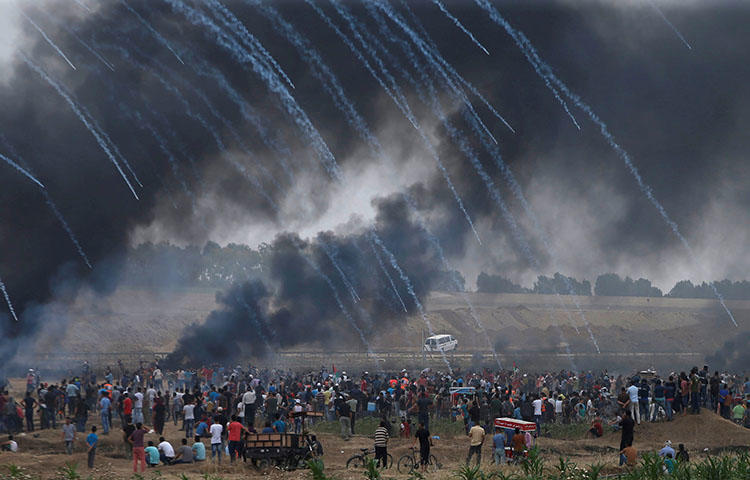 Tear gas canisters are fired by Israeli forces at Palestinian demonstrators on May 4, 2018. At least five Palestinian journalists were injured covering protests in the Gaza Strip on May 4 as the Israel Defense Forces used tear gas and fired live rounds to disperse demonstrators, according to reports. (Reuters/Mohammed Salem)