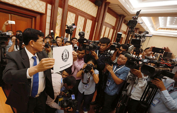 A National Election Committee officer in Phnom Penh shows the logo of the ruling Cambodian People's Party during a bid to determine the order of political parties on ballot papers ahead of the country's July election. Cambodia is cracking down on the press ahead of the elections, according to reports. (Reuters/Samrang Pring)