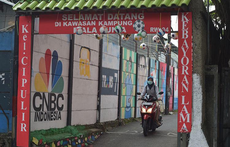A motorcyclist rides down an alley in Jakarta in June. An Indonesian journalist died while in custody in South Kalimantan. (AFP/Adek Berry)