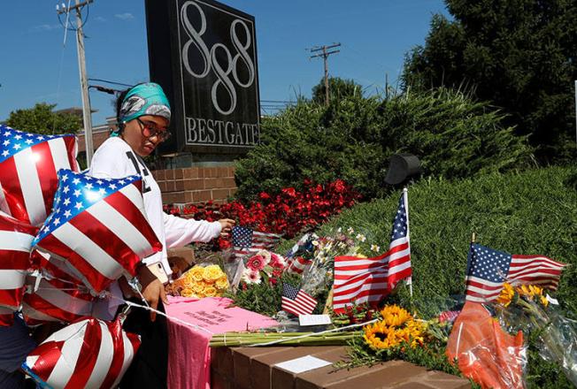A local resident lays an American flag at an impromptu memorial outside of the Capital Gazette, the day after a gunman killed five people at the newspaper in Annapolis, Maryland, on June 29, 2018. (Reuters/Leah Millis)