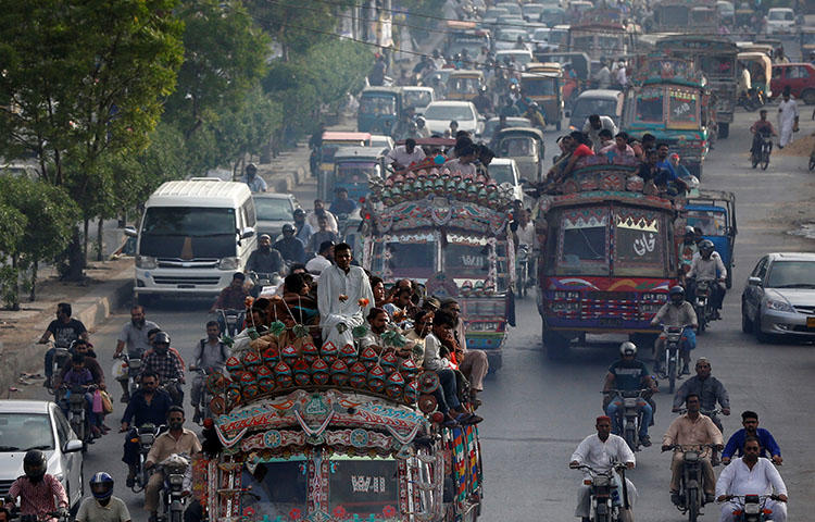 People travel atop vans as they head home during rush hours in Karachi, Pakistan in June 2017. Major General Asif Ghafoor, spokesperson for Pakistan's military and intelligence agencies, accused journalists of sharing anti-state remarks on social media, according to reports. (Reuters/Akhtar Soomro)