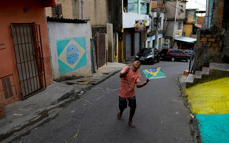 Um menino brinca na rua em Belo Horizonte, Brasil, em 17 de junho. Atacantes mataram um jornalista de rádio no estado do Pará, em 21 de junho. (Reuters/ Washington Alves)