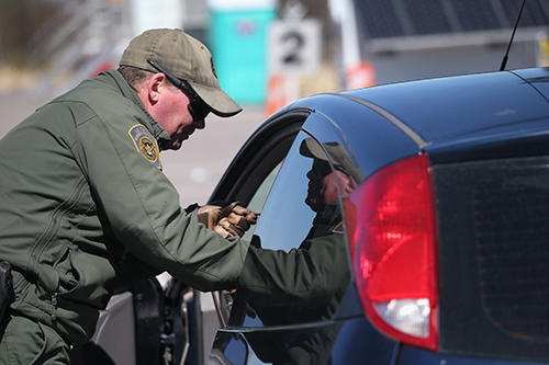 A U.S. Border Patrol agent speaks to an individual in a car at a border crossing. CPJ and other groups have documented cases of authorities stopping journalists at the border and inspecting their electronic devices. (AFP/Getty Images/John Moore)