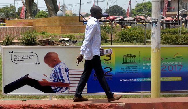 A man walks in Conakry, the capital of Guinea, on April 23, 2017. Guinea authorities arrested journalist Saliou Diallo on June 19, 2018, on defamation charges, according to reports. (AFP/Cellou Binani)