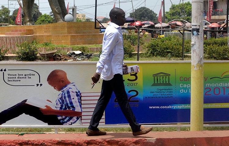 A man walks in Conakry, the capital of Guinea, on April 23, 2017. Guinea authorities arrested journalist Saliou Diallo on June 19, 2018, on defamation charges, according to reports. (AFP/Cellou Binani)